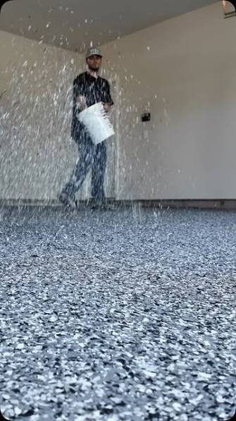 Installer broadcasting decorative flake across a fresh epoxy garage floor